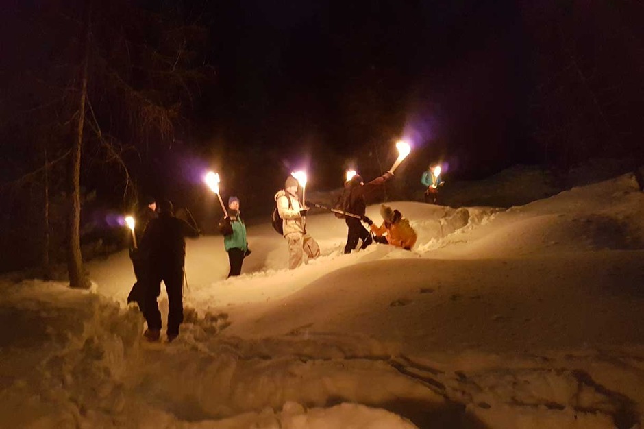 A Torch-Lit Evening on Snowshoes Followed by Dinner at a Mountain Lodge